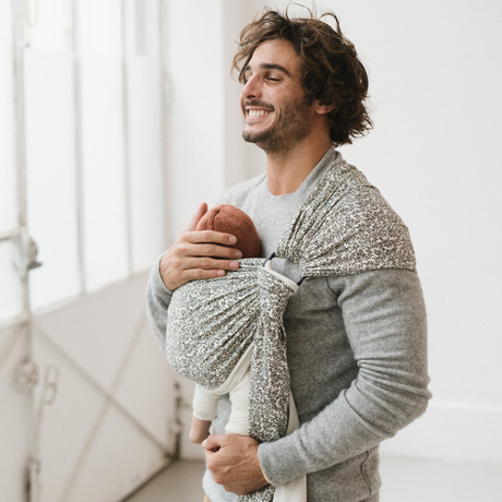 Papa en congé paternité portant son enfant